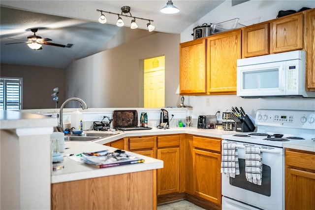 kitchen featuring lofted ceiling, ceiling fan, white appliances, and a sink