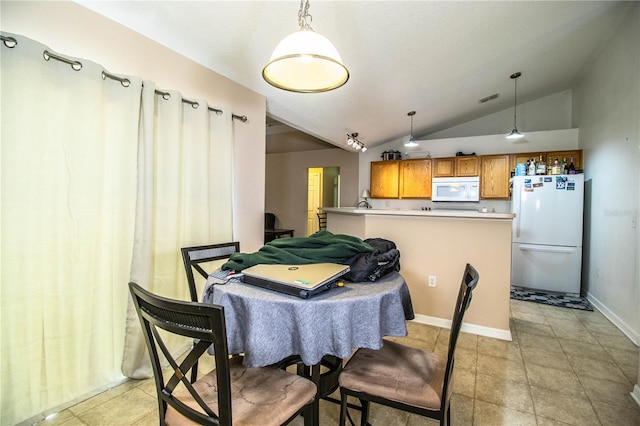 dining space with visible vents, vaulted ceiling, and baseboards