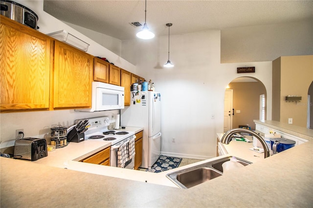 kitchen featuring a sink, white appliances, visible vents, light countertops, and arched walkways