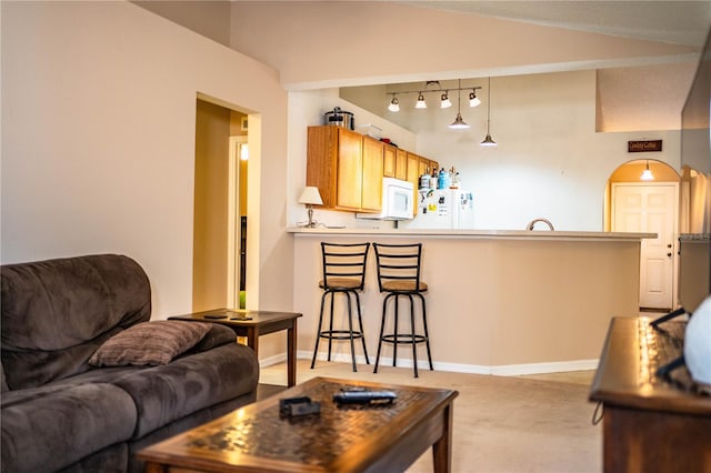 living room featuring lofted ceiling, baseboards, and light carpet