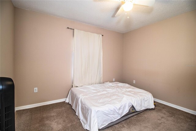 carpeted bedroom featuring baseboards, a ceiling fan, and a textured ceiling