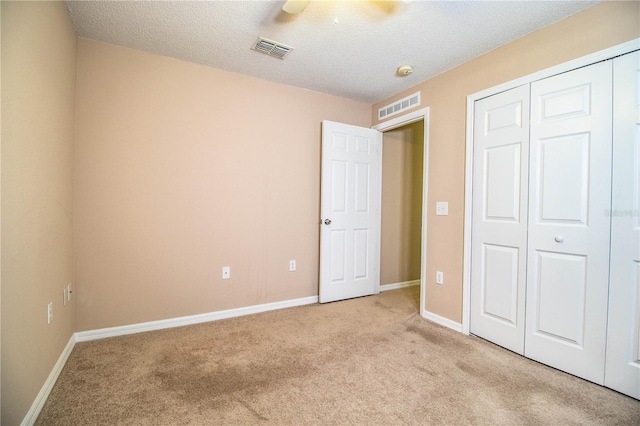 unfurnished bedroom featuring a closet, visible vents, and light carpet