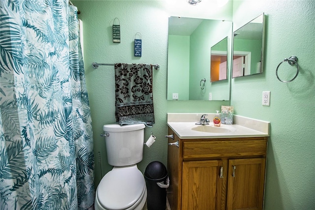 full bath with curtained shower, toilet, a textured wall, and vanity