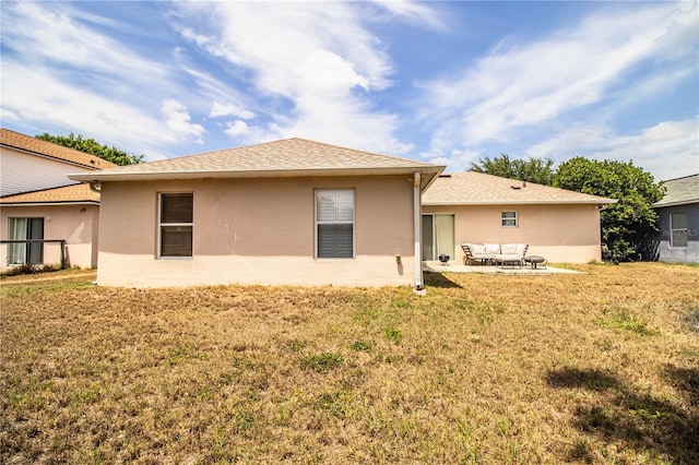 rear view of property featuring stucco siding, a yard, a patio, and an outdoor living space