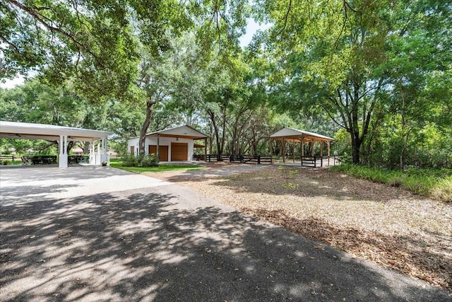 exterior space featuring a detached garage, a gazebo, and fence