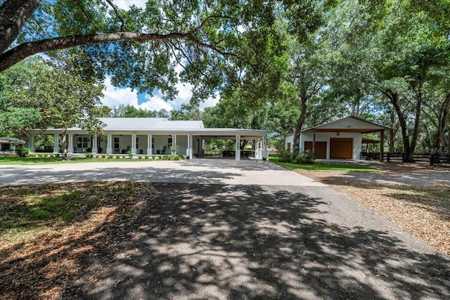 view of front facade with a garage, a carport, a porch, and aphalt driveway