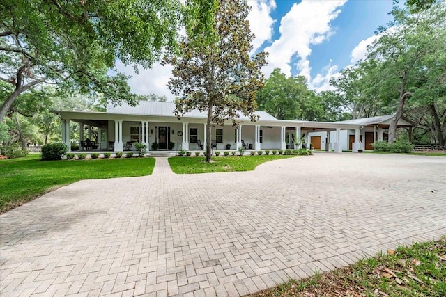 ranch-style home featuring a porch, curved driveway, and a front yard