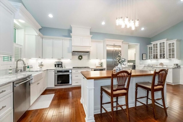 kitchen featuring a sink, appliances with stainless steel finishes, tasteful backsplash, and a center island