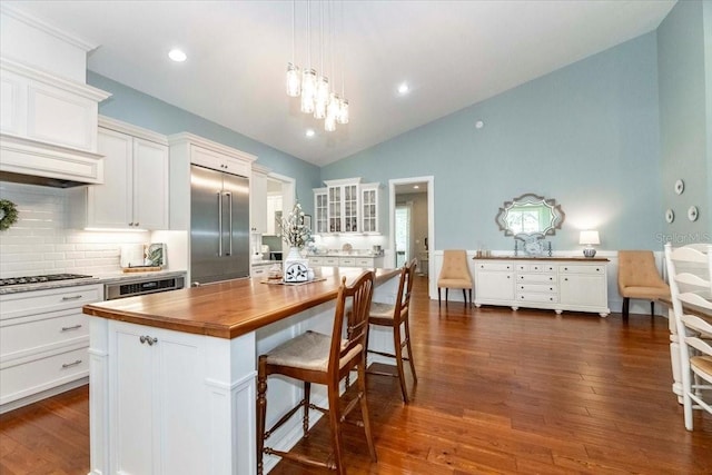 kitchen with gas cooktop, backsplash, butcher block counters, and built in fridge