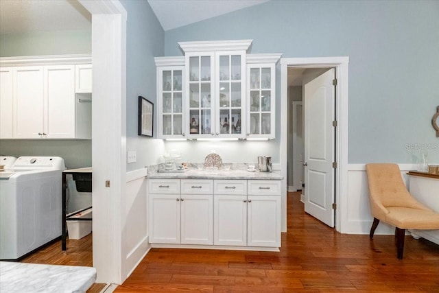 laundry area with cabinet space, washer and clothes dryer, and wood finished floors
