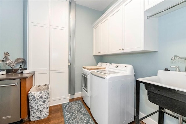 clothes washing area with a sink, dark wood-style flooring, cabinet space, and washer and dryer