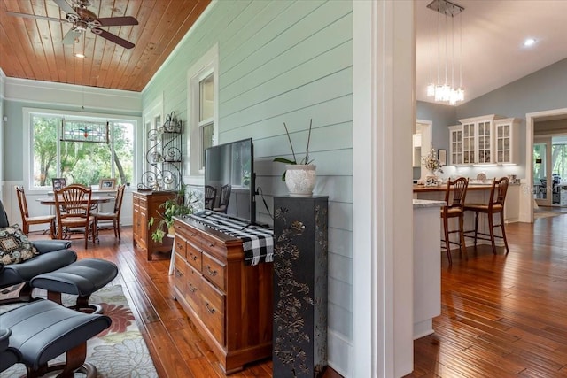 living area featuring a wealth of natural light, ceiling fan with notable chandelier, and hardwood / wood-style floors
