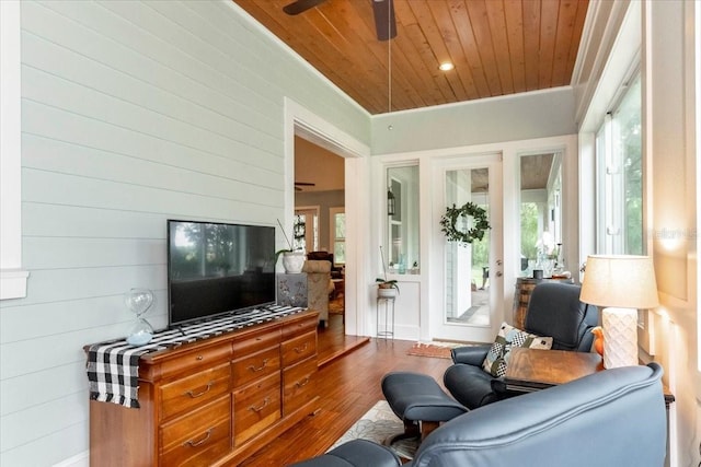 living area with ceiling fan, wood ceiling, plenty of natural light, and wood finished floors