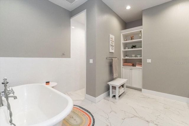 full bath with a freestanding bath, baseboards, recessed lighting, and marble finish floor