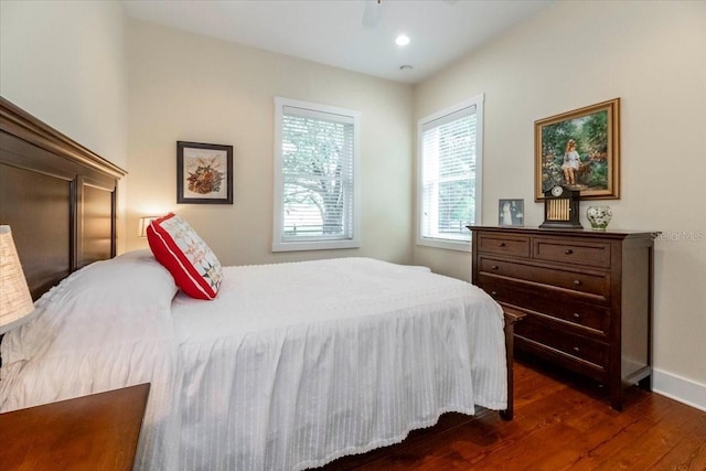 bedroom with baseboards and dark wood-type flooring