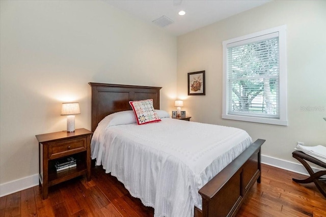 bedroom featuring baseboards, dark wood finished floors, and visible vents
