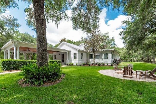 rear view of house with a yard, a ceiling fan, and a patio area