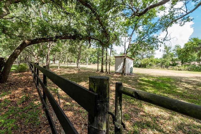 view of yard with an outbuilding, fence, and a storage shed