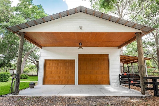 garage featuring a detached garage and fence