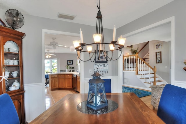 4116 4th Ave NE, Bradenton, FL 34208 - dining area with visible vents, stairway, a wainscoted wall, ceiling fan with notable chandelier, and light tile patterned floors