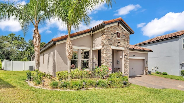 mediterranean / spanish-style house featuring a tiled roof, an attached garage, stone siding, and stucco siding