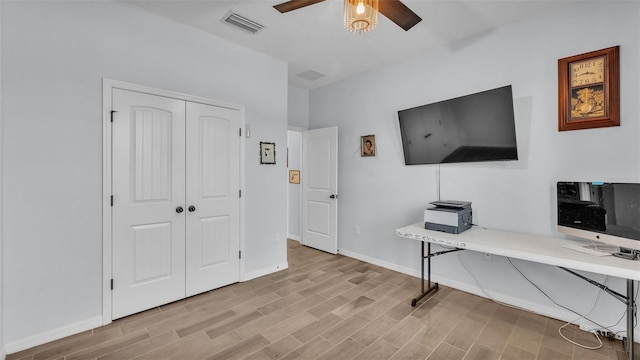 office with visible vents, a ceiling fan, light wood finished floors, and baseboards