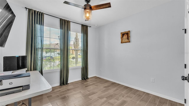 home office featuring baseboards, a ceiling fan, and a wealth of natural light