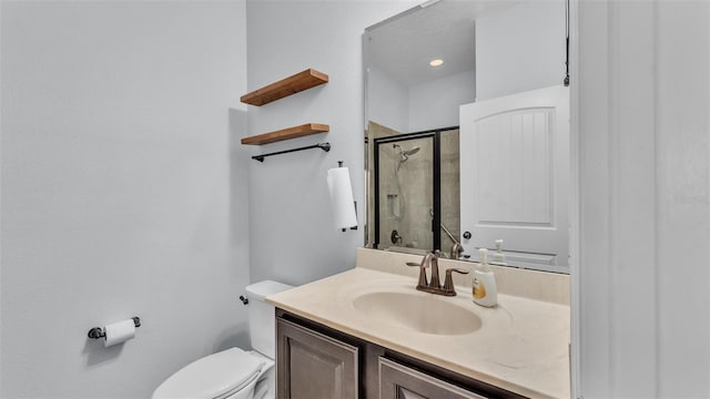 bathroom with vanity, toilet, and a stall shower