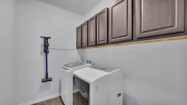 laundry area with baseboards, wood finished floors, cabinet space, and washer and dryer