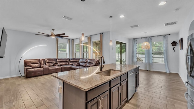 kitchen with a sink, baseboards, stainless steel dishwasher, and visible vents