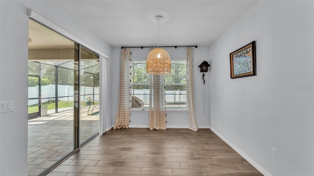 unfurnished dining area with baseboards and wood finished floors
