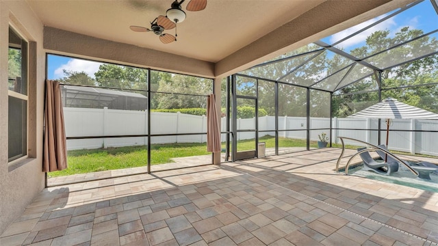 unfurnished sunroom with ceiling fan