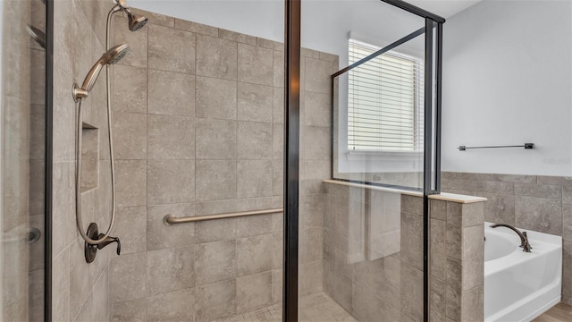 bathroom featuring a garden tub, a stall shower, a wealth of natural light, and tile walls