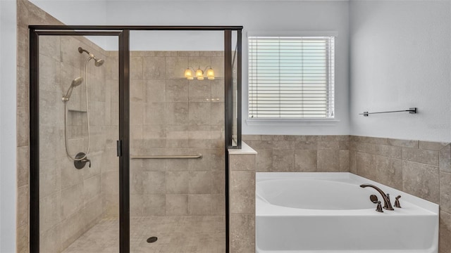 bathroom featuring a stall shower and a bath
