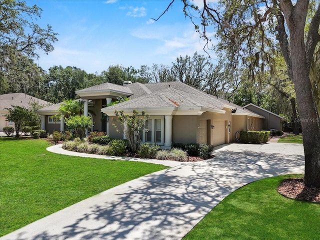 view of front facade with a front lawn, a garage, driveway, roof with shingles, and stucco siding