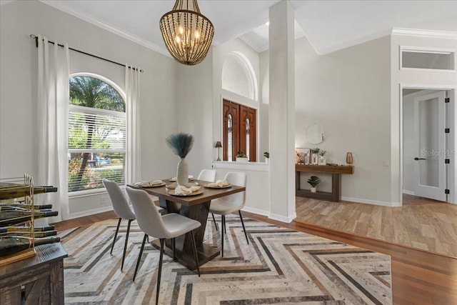 dining room with a chandelier, baseboards, ornamental molding, and wood finished floors