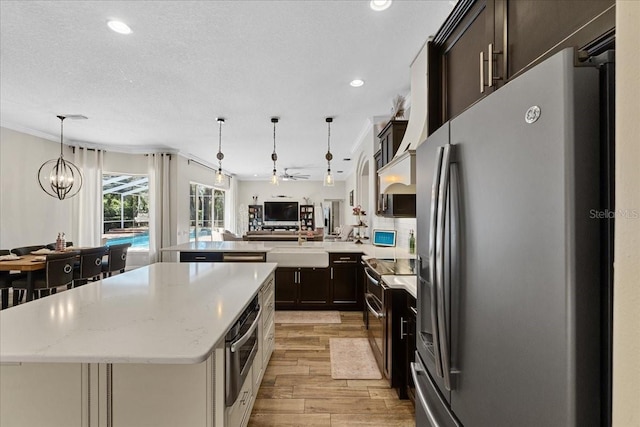 kitchen with light wood-style floors, stainless steel appliances, a center island, open floor plan, and recessed lighting