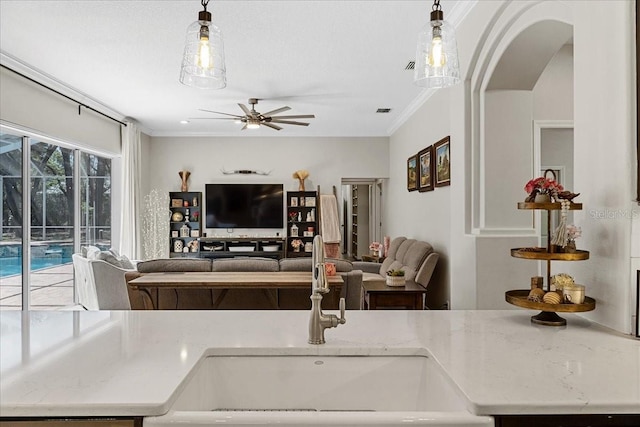 interior space with crown molding, arched walkways, ceiling fan, and visible vents
