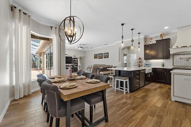 dining room featuring baseboards, light wood-type flooring, recessed lighting, ornamental molding, and ceiling fan with notable chandelier