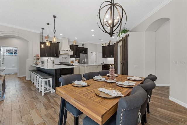dining space with ornamental molding, a notable chandelier, and baseboards