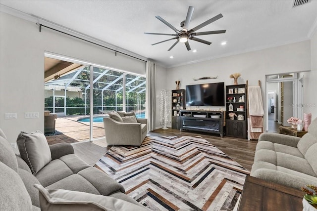 living area with visible vents, ceiling fan, ornamental molding, a sunroom, and wood finished floors