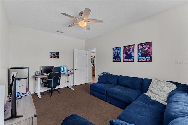 carpeted living area featuring a textured ceiling, visible vents, and ceiling fan