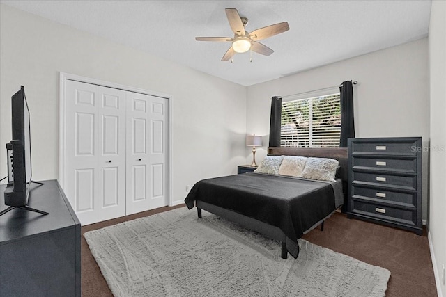 bedroom featuring dark carpet, ceiling fan, and a closet