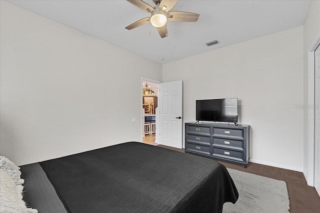 bedroom featuring dark carpet, visible vents, ceiling fan, and baseboards
