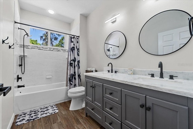 full bathroom with shower / tub combo with curtain, wood finished floors, toilet, and a sink