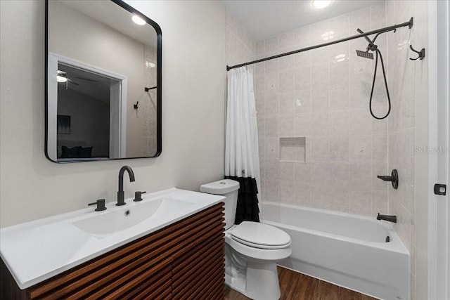 full bath with wood finished floors, ceiling fan, toilet, vanity, and shower / tub combo