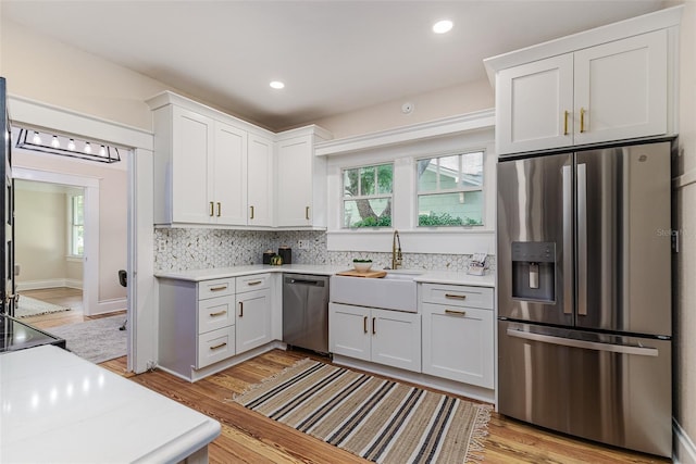 746 Mississippi Ave, Lakeland, FL 33801 - kitchen featuring a sink, decorative backsplash, stainless steel appliances, white cabinetry, and light countertops