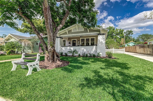 746 Mississippi Ave, Lakeland, FL 33801 - bungalow-style house with a front lawn, fence, brick siding, and a chimney