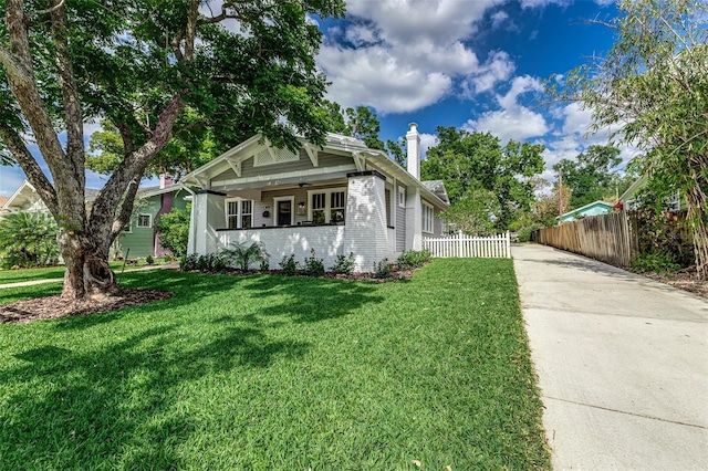 746 Mississippi Ave, Lakeland, FL 33801 - view of front of home featuring driveway, a chimney, a front yard, fence, and brick siding
