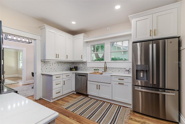 746 Mississippi Ave, Lakeland, FL 33801 - kitchen featuring a sink, decorative backsplash, stainless steel appliances, white cabinetry, and light countertops